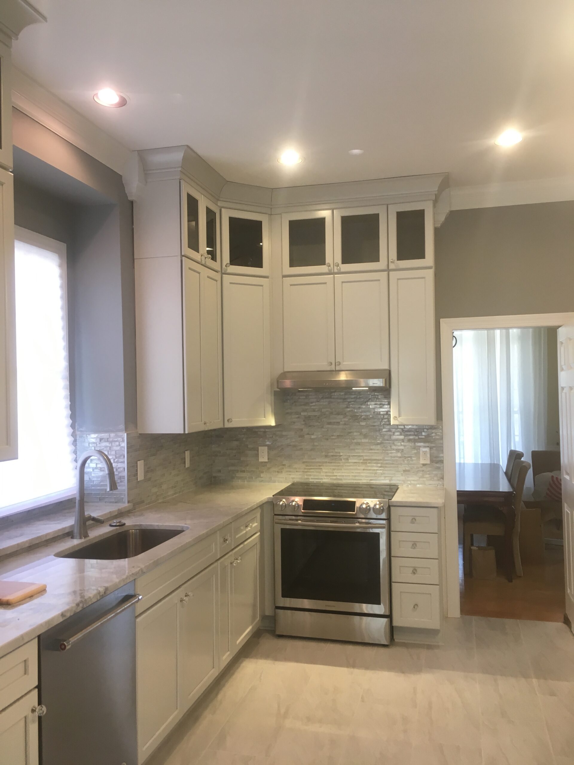 Kitchen cooking wall with glass mosaic tile backsplash and stainless range