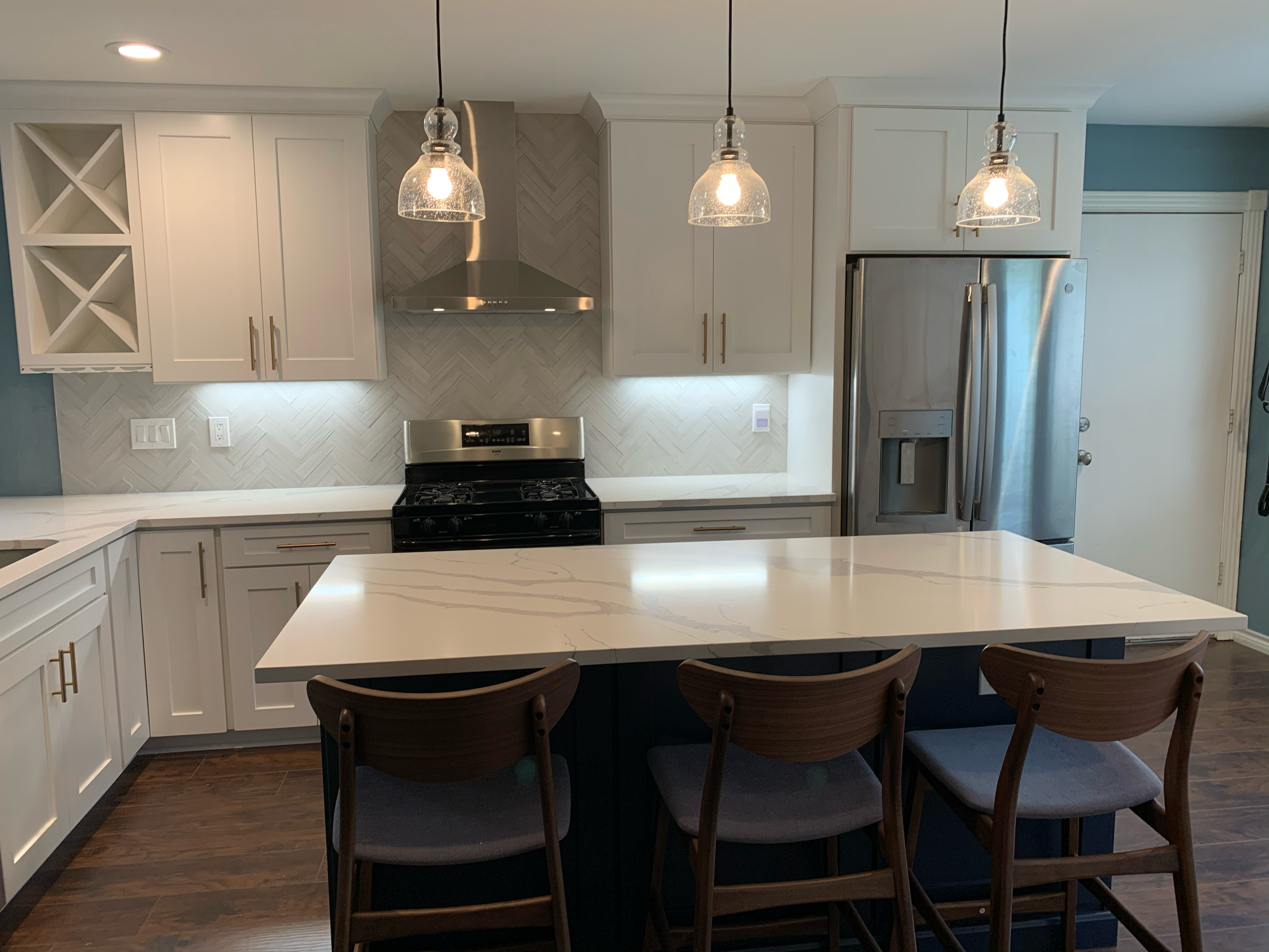 View across the island toward the range and refrigerator wall